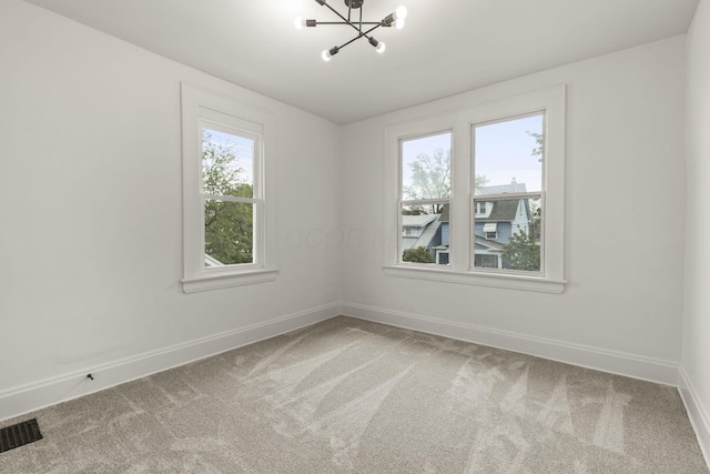 147 N Ogden Ave, Columbus, OH 43204 - carpeted spare room with baseboards, visible vents, and a notable chandelier