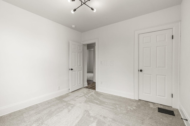 147 N Ogden Ave, Columbus, OH 43204 - unfurnished bedroom featuring an inviting chandelier, carpet floors, baseboards, and visible vents