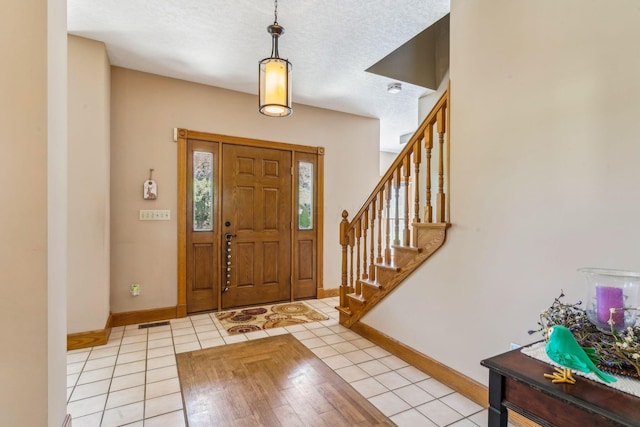 125 W Woodmere Dr, Tiffin, OH 44883 - foyer featuring light tile patterned floors, baseboards, stairs, and a textured ceiling
