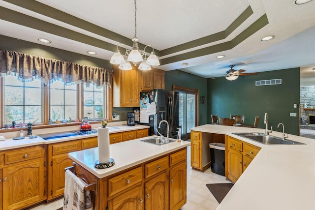 125 W Woodmere Dr, Tiffin, OH 44883 - kitchen with visible vents, a sink, black refrigerator with ice dispenser, and a kitchen island with sink
