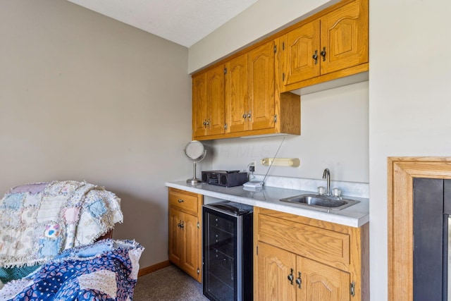 125 W Woodmere Dr, Tiffin, OH 44883 - kitchen featuring wine cooler, baseboards, light countertops, brown cabinets, and a sink