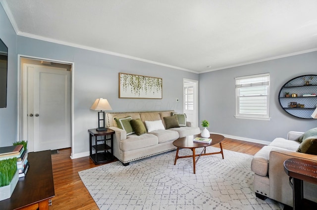 living area with baseboards, crown molding, and wood finished floors