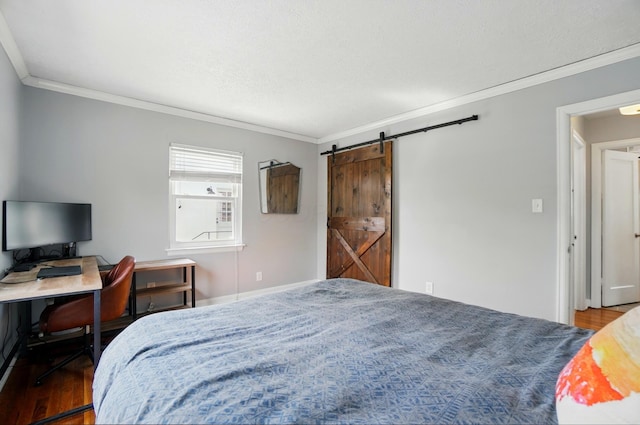 bedroom featuring crown molding, wood finished floors, and a barn door