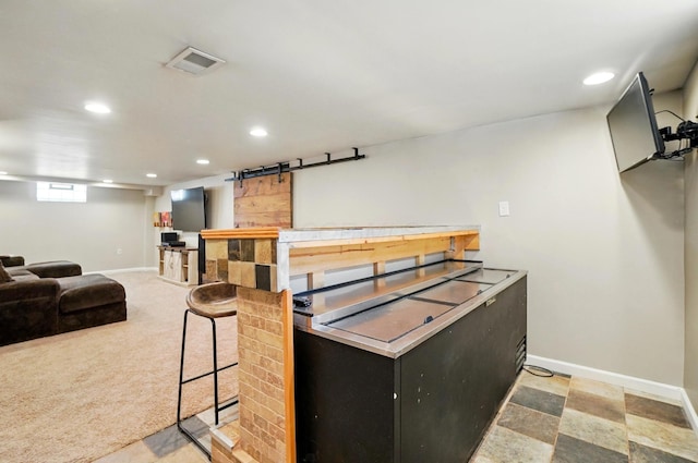 kitchen featuring visible vents, a barn door, baseboards, dark cabinetry, and recessed lighting