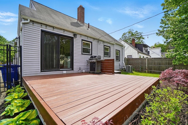 wooden deck featuring a grill, central air condition unit, and fence