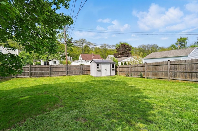 view of yard featuring an outdoor structure, a storage shed, and a fenced backyard