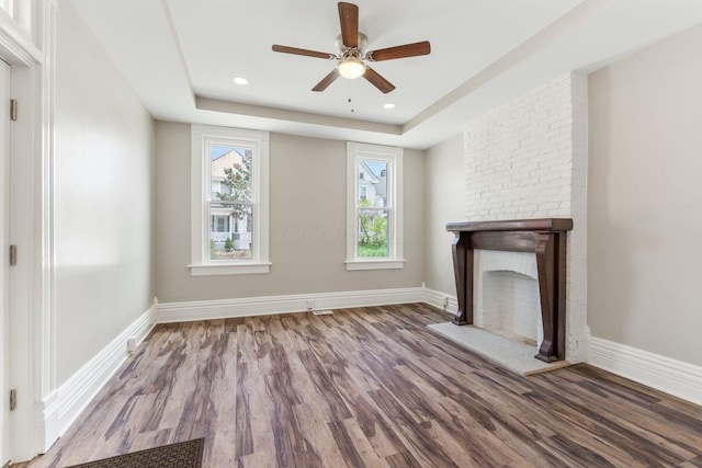 61 Dakota Ave, Columbus, OH 43222 - unfurnished living room with ceiling fan, a fireplace, baseboards, wood finished floors, and a tray ceiling