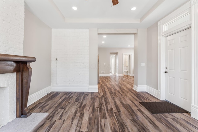 61 Dakota Ave, Columbus, OH 43222 - unfurnished living room with a fireplace, brick wall, baseboards, wood finished floors, and a tray ceiling