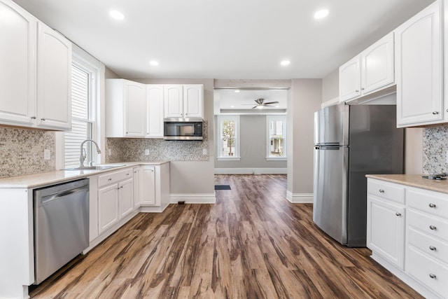 61 Dakota Ave, Columbus, OH 43222 - kitchen featuring appliances with stainless steel finishes, tasteful backsplash, dark wood finished floors, a sink, and white cabinets