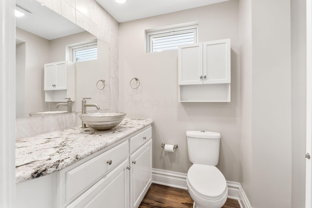 61 Dakota Ave, Columbus, OH 43222 - half bathroom featuring toilet, baseboards, plenty of natural light, and wood finished floors