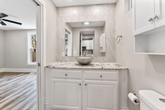 61 Dakota Ave, Columbus, OH 43222 - bathroom featuring a ceiling fan, wood finished floors, vanity, baseboards, and toilet