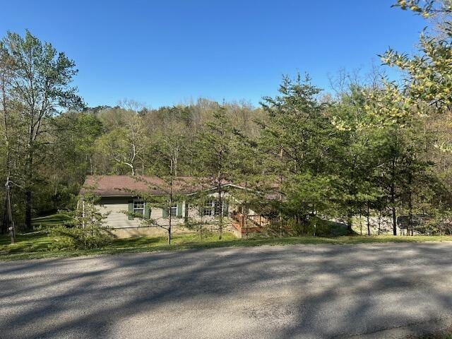 view of front of property featuring a view of trees
