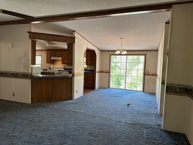 35310 Geiger Rd, Logan, OH 43138 - kitchen featuring dark carpet, dark countertops, a chandelier, a textured ceiling, and healthy amount of natural light