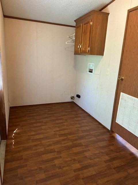 35310 Geiger Rd, Logan, OH 43138 - laundry area with dark wood-type flooring, washer hookup, crown molding, a textured ceiling, and cabinet space
