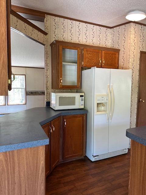 35310 Geiger Rd, Logan, OH 43138 - kitchen featuring white appliances, wallpapered walls, a textured ceiling, dark countertops, and dark wood-style flooring