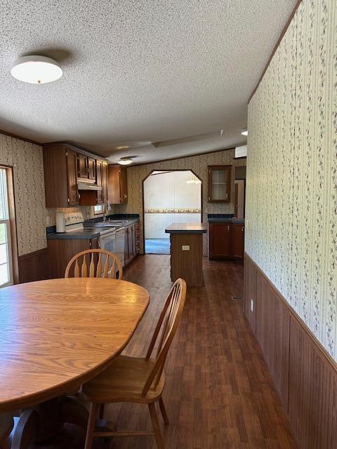 35310 Geiger Rd, Logan, OH 43138 - dining room with wallpapered walls, wainscoting, a textured ceiling, wooden walls, and dark wood-type flooring