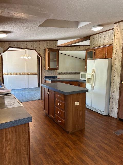 35310 Geiger Rd, Logan, OH 43138 - kitchen with white appliances, wallpapered walls, a textured ceiling, dark countertops, and a kitchen island