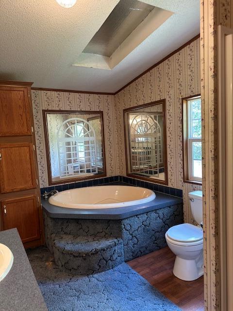 35310 Geiger Rd, Logan, OH 43138 - bathroom with toilet, wood finished floors, a garden tub, and a textured ceiling