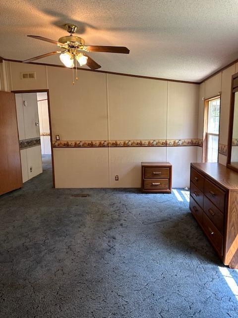 35310 Geiger Rd, Logan, OH 43138 - carpeted empty room with a textured ceiling, ceiling fan, and a decorative wall