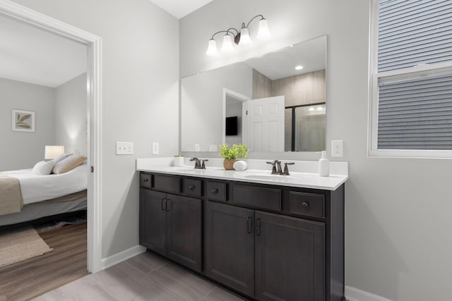 6464 Rockhold Dr, Westerville, OH 43081 - full bathroom featuring double vanity, baseboards, an enclosed shower, wood finished floors, and ensuite bath