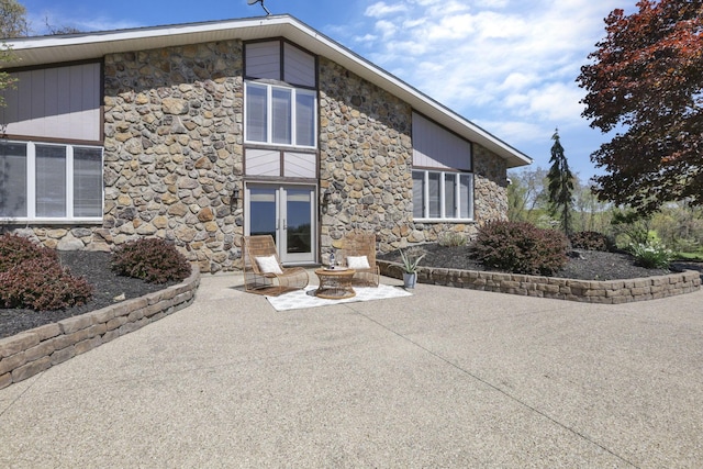 back of house with a patio area and stone siding