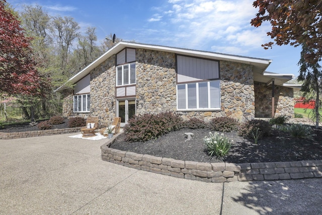 view of front of property featuring a patio and stone siding