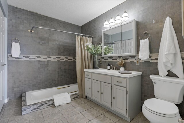 full bathroom featuring tile patterned flooring, vanity, toilet, tile walls, and tiled shower