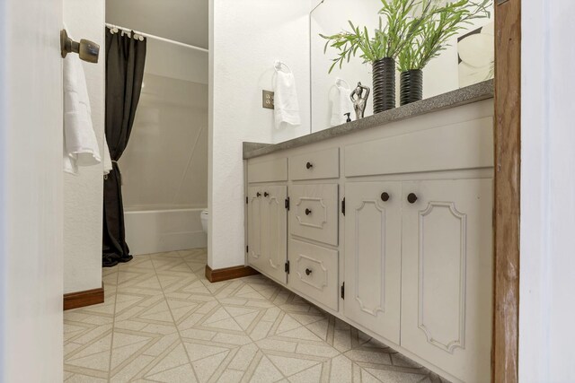 full bath with vanity, baseboards, shower / bath combo with shower curtain, and toilet