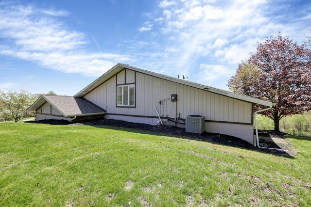 rear view of house featuring a lawn and cooling unit