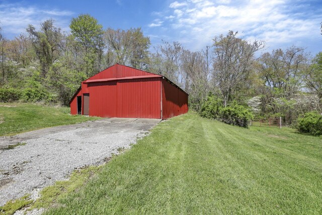 view of pole building with a lawn and driveway