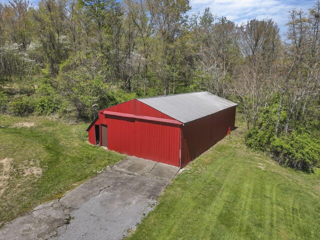 view of pole building featuring a yard and a forest view