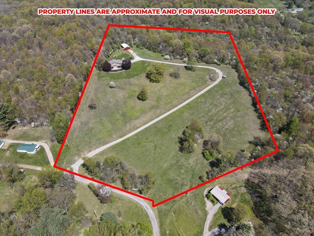 bird's eye view with a wooded view
