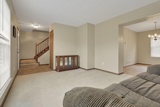 6495 Saylor St, Canal Winchester, OH 43110 - living room with light carpet, stairs, a chandelier, and baseboards