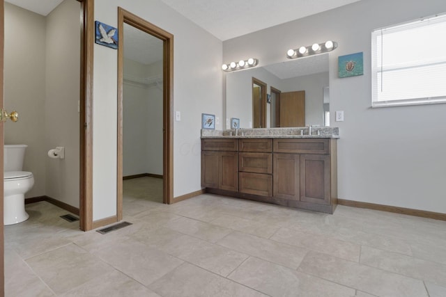6495 Saylor St, Canal Winchester, OH 43110 - bathroom with toilet, double vanity, a spacious closet, and baseboards