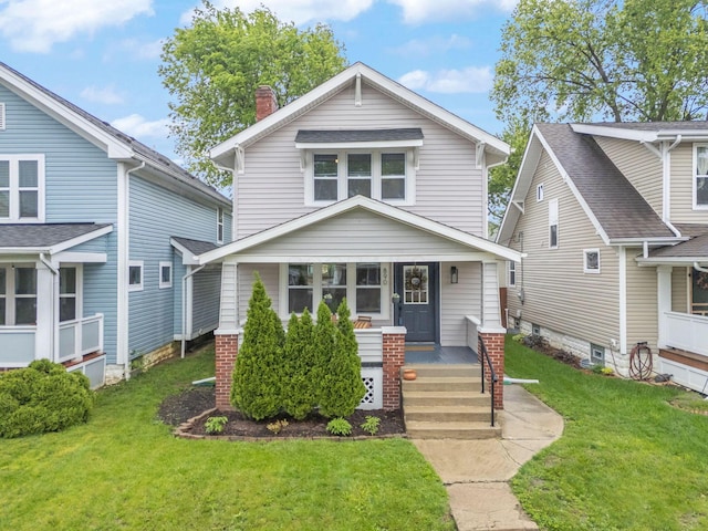 traditional style home with a front lawn, a porch, and a chimney