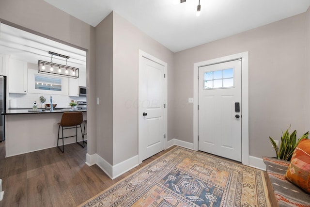 foyer entrance with wood finished floors and baseboards