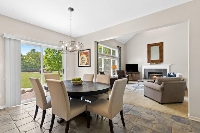2543 Kemperwood Dr, Blacklick, OH 43004 - dining area featuring a tile fireplace, vaulted ceiling, a chandelier, and baseboards