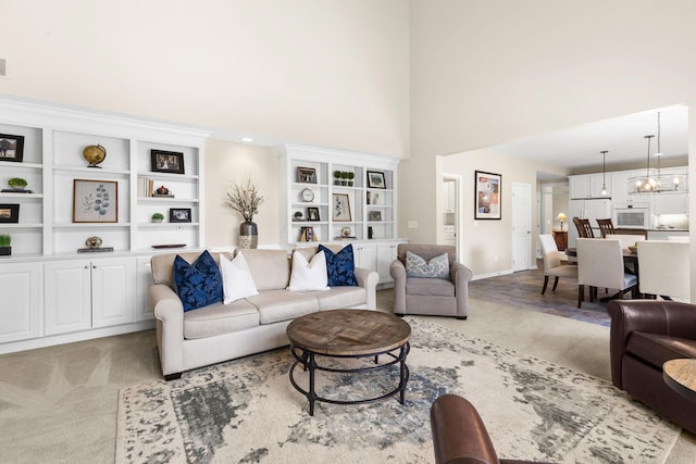 2543 Kemperwood Dr, Blacklick, OH 43004 - living room with light colored carpet, a towering ceiling, built in features, and baseboards