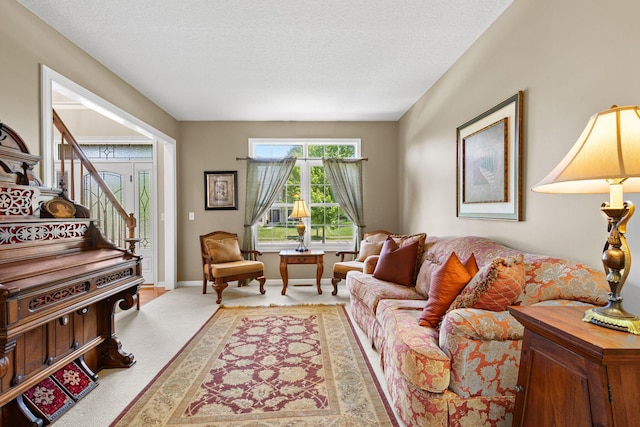 2543 Kemperwood Dr, Blacklick, OH 43004 - carpeted living room with a textured ceiling, stairs, and baseboards