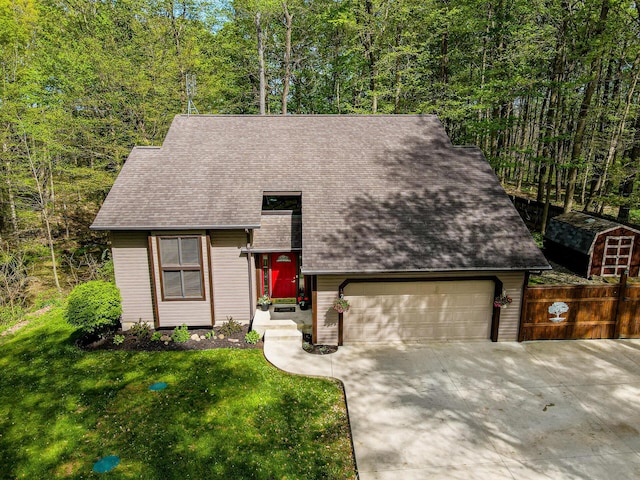 view of front of house featuring a shingled roof, an attached garage, driveway, and a front lawn