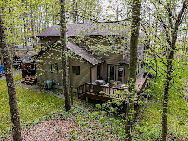 back of house with a shingled roof, central AC, and a deck