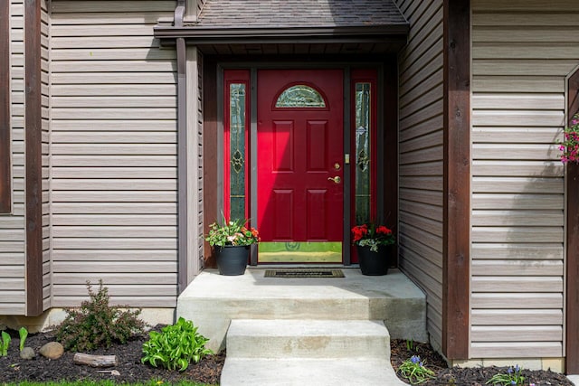 entrance to property featuring a shingled roof