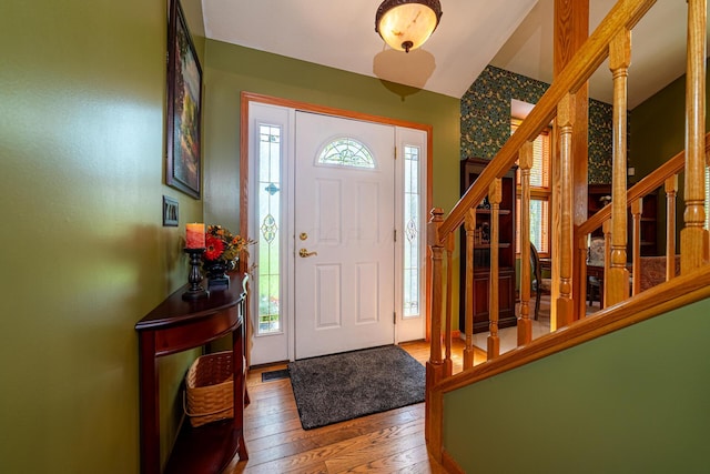 entrance foyer featuring stairs, vaulted ceiling, and hardwood / wood-style floors