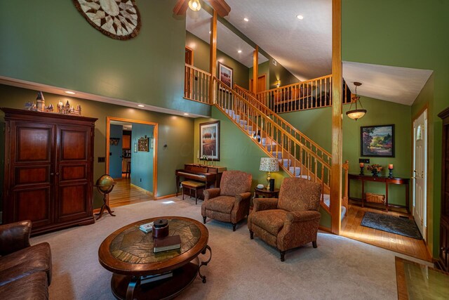 living area with a high ceiling, carpet floors, stairs, recessed lighting, and baseboards