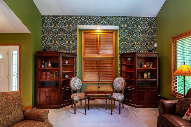 sitting room with carpet floors and wallpapered walls