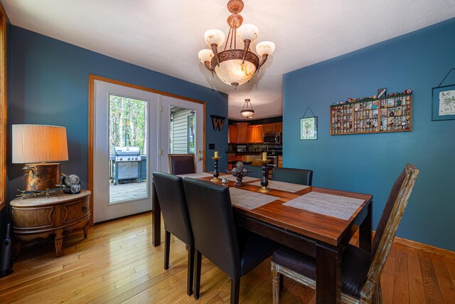 dining area with light wood-style flooring and a chandelier