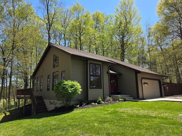 view of front facade with roof with shingles, an attached garage, concrete driveway, and a front yard
