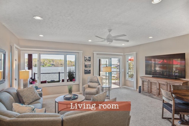 carpeted living area with a textured ceiling, ceiling fan, and recessed lighting