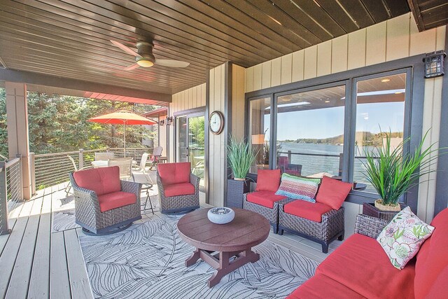 deck with ceiling fan, a water view, and outdoor lounge area