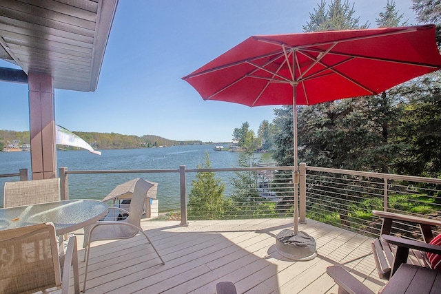 wooden deck featuring outdoor dining area and a water view